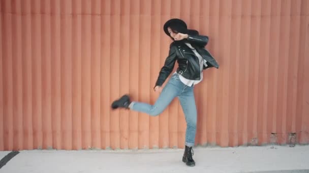 Looping de mujer joven flexible bailando al aire libre actuando sola sobre fondo de pared urbana — Vídeos de Stock