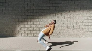 Yetenekli break dansçıların dans döngüsü geriye doğru eğiliyor kollarını hareket ettiriyor dışarıda eğleniyor.