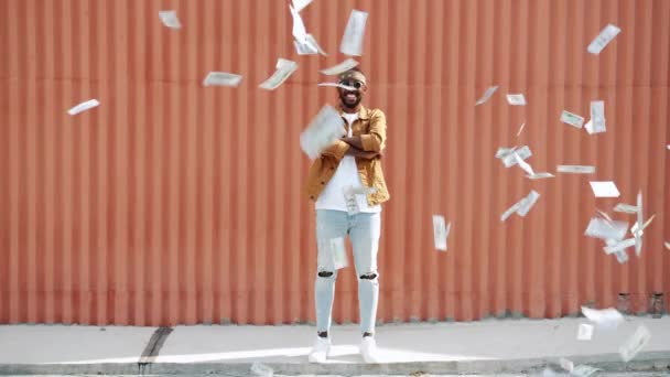 Looping de chico afroamericano emocionado lanzando y atrapando dinero en efectivo sonriendo al aire libre — Vídeos de Stock