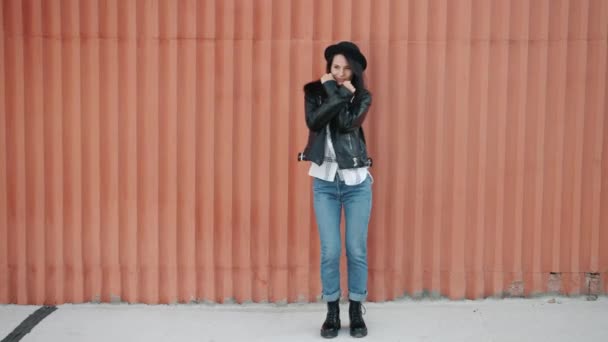 Boucle d'attrayant jeune femme hipster dansant à l'extérieur sur fond de mur urbain — Video