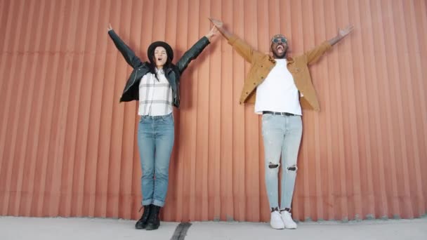 Dance loop of creative youth Afro-American man and Caucasian woman jumping dancing outdoors — Stock Video