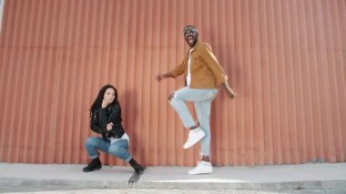 Havalı erkek ve kızın yavaş çekim portresi. Karışık ırk çifti dışarıda dans edip gülümsüyor.