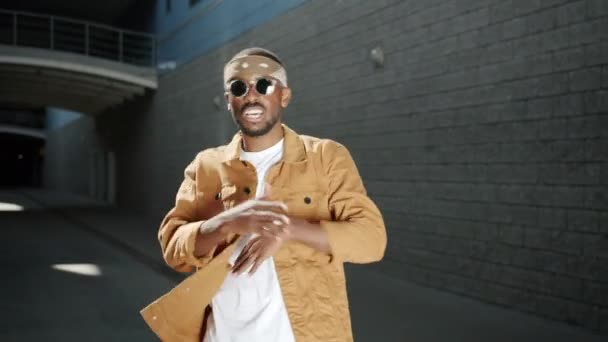 Афроамериканський реп - співак танцює і жестикує на вулиці на міському фоні — стокове відео