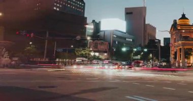 Canlı bir kentsel gece sahnesi, yoğun kavşaklardan geçen ışıklı binalar ve araçlarla sürekli trafik hareketlerini gösteriyor. Zaman aşımı, Seul, Güney Kore