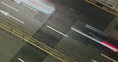 Araçlar, görünür şerit işaretleriyle ve bulanık hareket efektleriyle sürekli trafik akışının altını çizerek bir şehir caddesinde ilerliyorlar. Zaman aşımı, Seul, Güney Kore