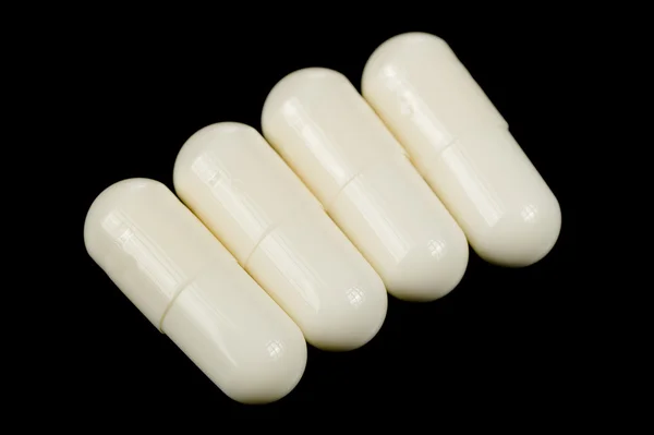 Witte Capsules met geneeskunde op zwarte achtergrond — Stockfoto