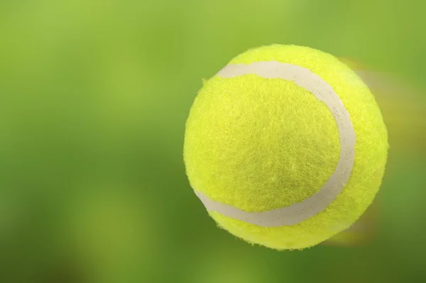 Rasen-Tennisball in Bewegung auf grünem Hintergrund — Stockfoto