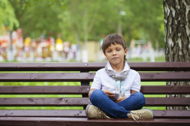 Bir tezgah ve mobil telefon ederken küçük bir çocuk oturur 