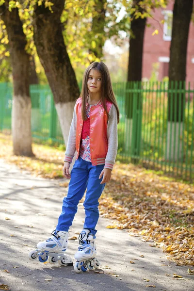 Giovane ragazza andare sui pattini a rotelle, all'aperto, la sera estate — Foto Stock