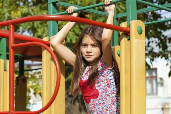 Beautiful little girl on green background of summer city park — Stock Photo, Image