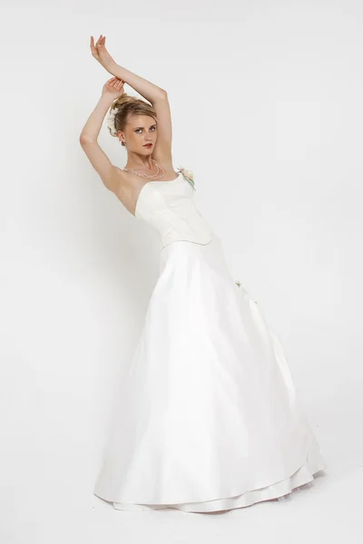 Portrét nádherná nevěsta na sobě svatební šaty nad šedé pozadí — Stock fotografie