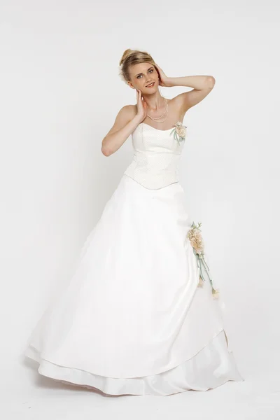 Porträt einer hinreißenden Braut im Brautkleid über grauem Rücken — Stockfoto