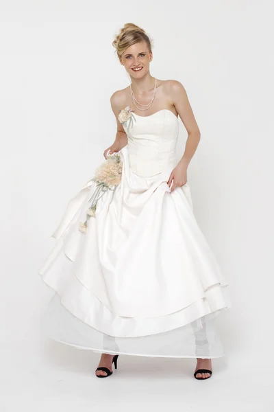 Портрет великолепной невесты в свадебном платье поверх серого рюкзака — стоковое фото