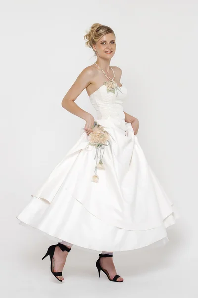 Портрет великолепной невесты в свадебном платье поверх серого рюкзака — стоковое фото