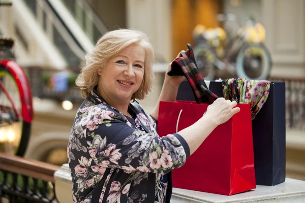 Mulher feliz madura com sacos de compras — Fotografia de Stock