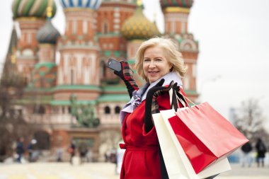 Alışveriş torbaları ile mutlu olgun kadın
