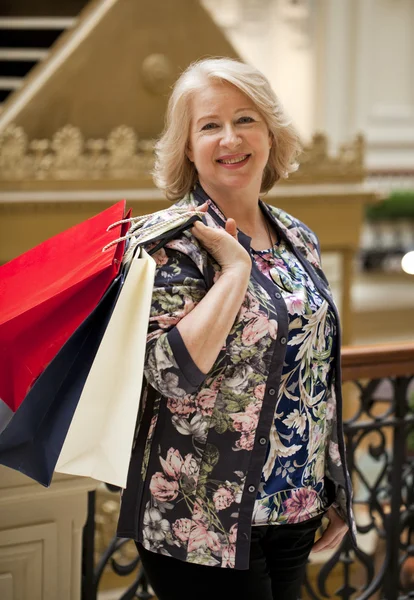 Зрелая счастливая женщина с сумками — стоковое фото