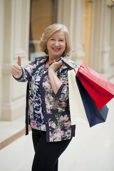 Madura feliz mujer con bolsas de compras —  Fotos de Stock