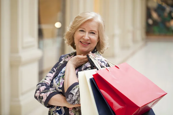 Reife, glückliche Frau mit Einkaufstüten — Stockfoto