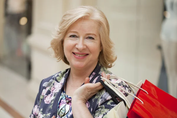 Volwassen gelukkig vrouw met shopping tassen — Stockfoto