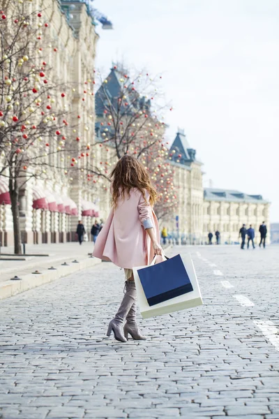 Mladá žena v růžové kabátě chodí na Rudém náměstí v Moskvě — Stock fotografie