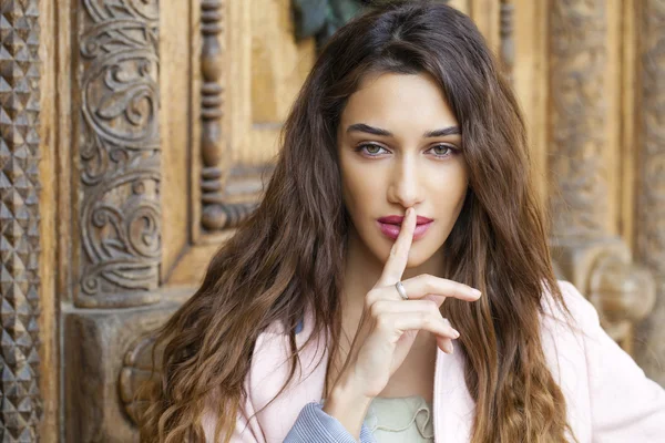 Porträtt av attraktiv ung kvinna med fingret på läppar — Stockfoto