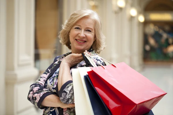 Mulher feliz madura com sacos de compras — Fotografia de Stock