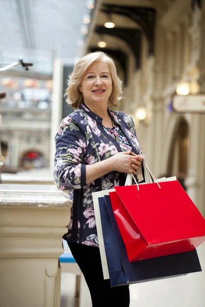 Volwassen gelukkig vrouw met shopping tassen — Stockfoto