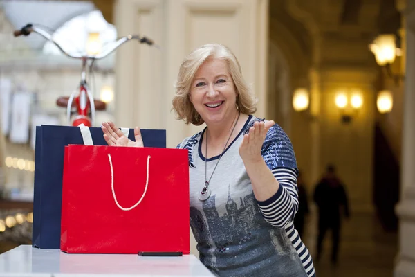 Volwassen gelukkig vrouw met shopping tassen — Stockfoto