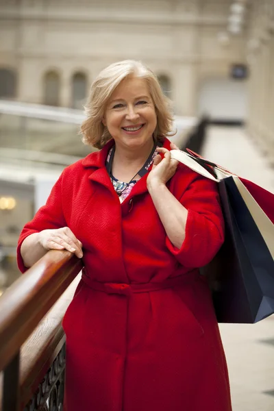 Madura feliz mujer con bolsas de compras —  Fotos de Stock