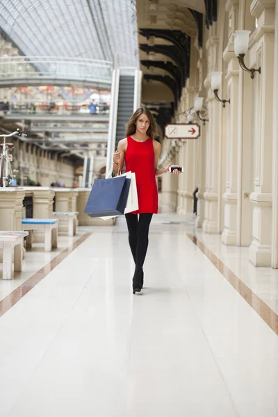 Piros ruhás, séta a boltban, fiatal nő — Stock Fotó