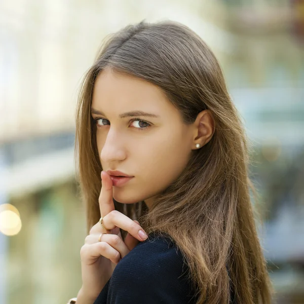 Ritratto di attraente giovane donna dai capelli con dito sulle labbra — Foto Stock