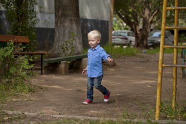 Sarışın bebek oğlan mavi tişört ve kot pantolon