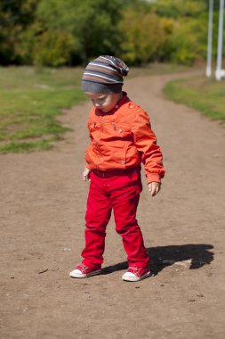 İki yıllık çocuk parkta yürüyor