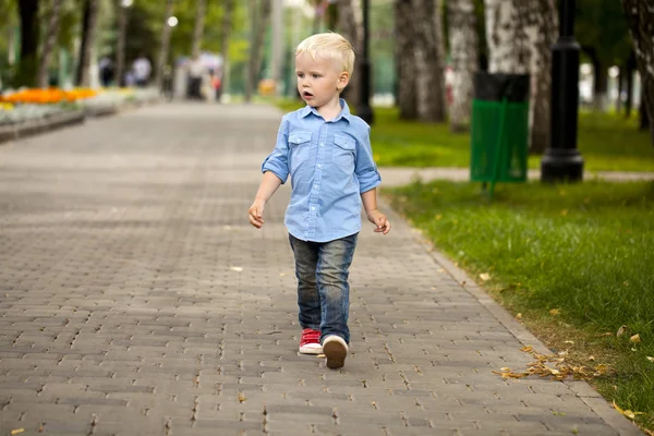 Blond pojke i blå skjorta och jeans — Stockfoto