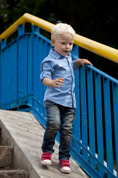 Menino loiro de camisa azul e jeans — Fotografia de Stock