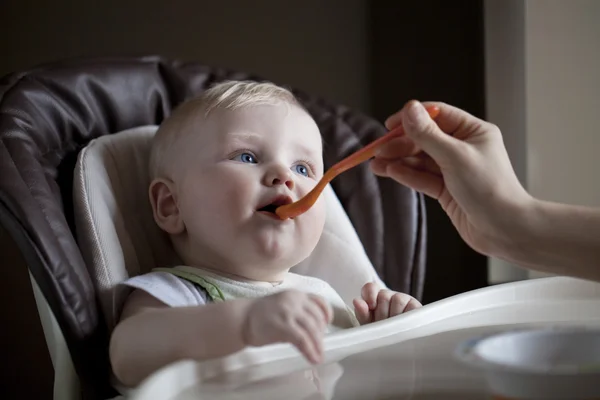 Babyjongen zitten aan een tafel voor het voederen — Stockfoto