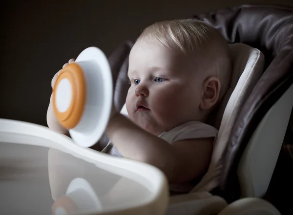 Boş bir levha ile beslenme için bir masada oturan erkek bebek — Stok fotoğraf