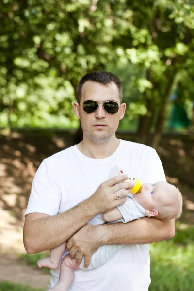 Father drinking milk his bottle baby boy — Stock Photo, Image