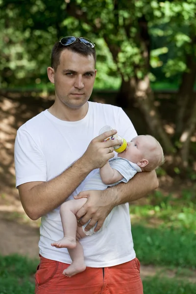 Father drinking milk his bottle baby boy — Stock Photo, Image