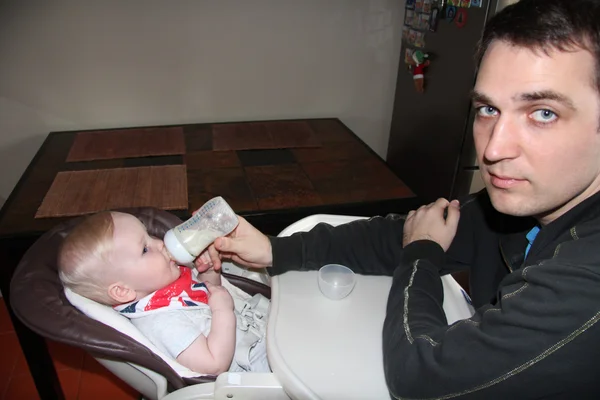 Baby boy sitting at a table for feeding — Stock Photo, Image