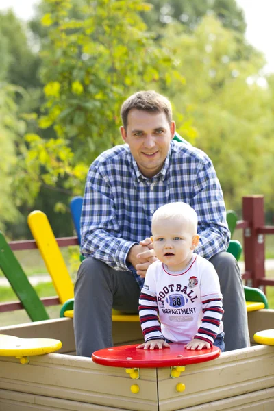 Отец с двухлетним сыном на детской площадке — стоковое фото