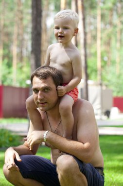 Genç bir baba omuzlarında oturan küçük çocuk