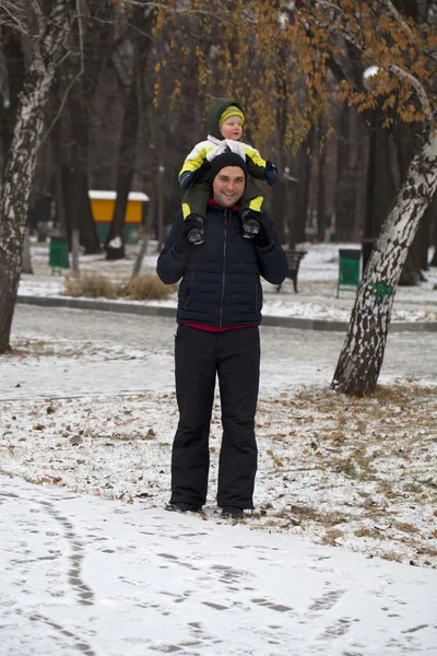 Отец и сын гуляют в зимнем парке — стоковое фото
