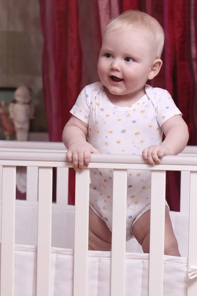 Little boy sitting in a crib — Stock Photo, Image