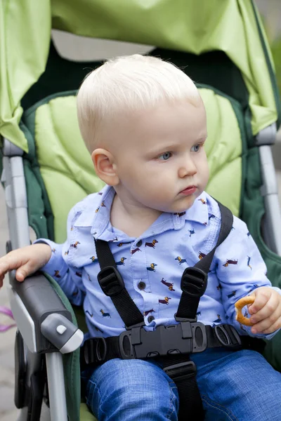 Маленький хлопчик сидить у колясці — стокове фото