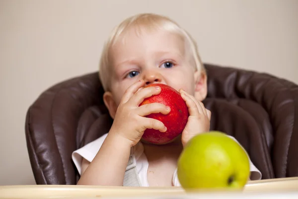Ostrost na apple. Dva roky chlapeček sedí u večeře — Stock fotografie