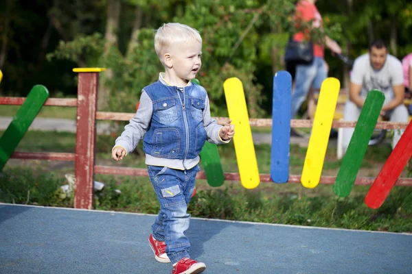 Niño alegre corriendo por el patio de recreo —  Fotos de Stock