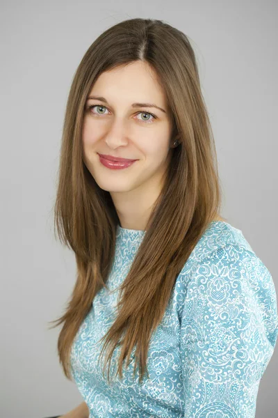 Portrait of a beautiful young woman in a turquoise dress on a gr — Stock Photo, Image