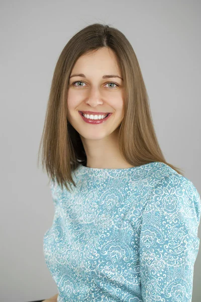 Portrait of a beautiful young woman in a turquoise dress on a gr — Stock Photo, Image